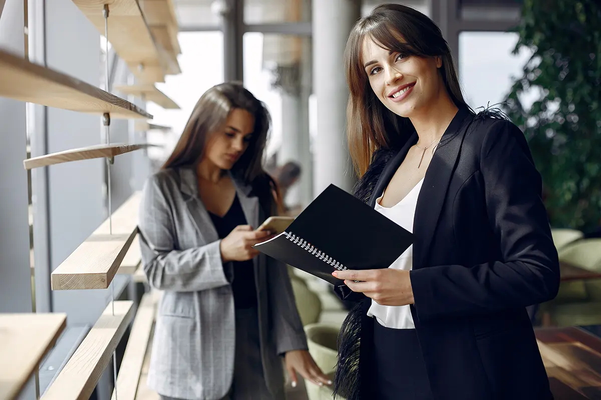 Foto de uma mulher consultora comercial sorridente trabalhando com um caderno nas mãos.