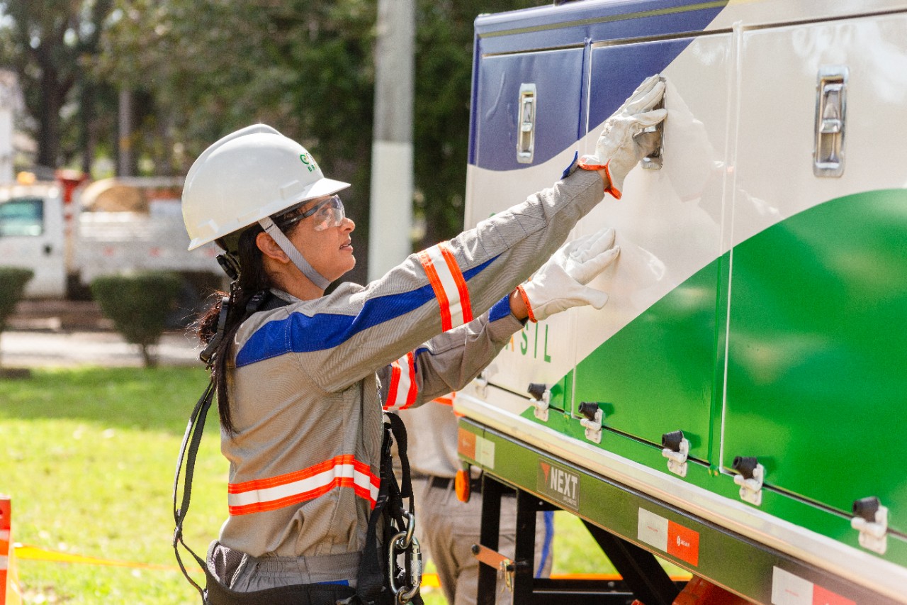Foto de mulher profissional Eletricista da Enel trabalhando.